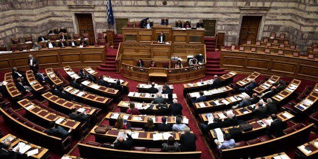 Lawmakers debate at the Greek parliament in Athens on October 16, 2015, as Greece's parliament is expected to approve later a first batch of reforms and tax cuts stemming from its third EU bailout. The vote, scheduled for around midnight, is expected to be won by the leftist government of Prime Minister Alexis Tsipras, which has 155 lawmakers in the 300-seat chamber. AFP PHOTO / LOUISA GOULIAMAKI (Photo credit should read LOUISA GOULIAMAKI/AFP/Getty Images)