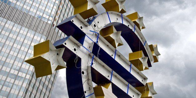 Renovation works are under way on the statue of the Euro logo in front of the former headquarters of the European Central Bank (ECB) in Frankfurt am Main, western Germany, on July 9, 2015. AFP PHOTO / DPA / BORIS ROESSLER +++ GERMANY OUT (Photo credit should read BORIS ROESSLER/AFP/Getty Images)