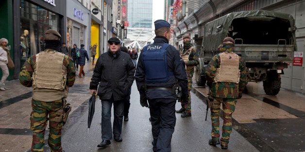 Belgian Army soldiers and police patrol an otherwise busy shopping street in Brussels on Saturday, Nov. 21, 2015. Belgium raised its security level to its highest degree on Saturday as the manhunt continues for extremist Salah Abdeslam who took part in the Paris attacks. The security levels shut down all metro lines and shuttered many shops as well as canceling sports matches. (AP Photo/Virginia Mayo)