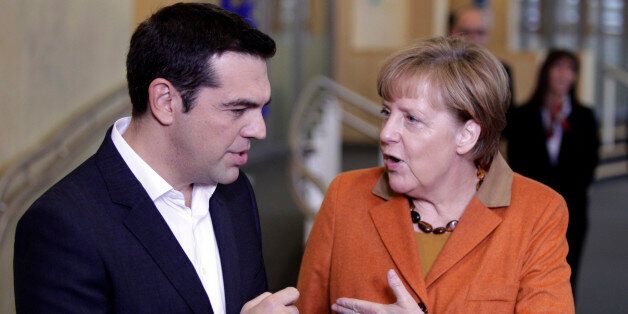 German Chancellor Angela Merkel, right, speaks with Greek Prime Minister Alexis Tsipras prior to a round table meeting during an EU summit at EU headquarters in Brussels on Sunday, Oct. 25, 2015. EU leaders meet on Sunday to discuss refugee flows along the Western Balkans route. (AP Photo/Francois Walschaerts)