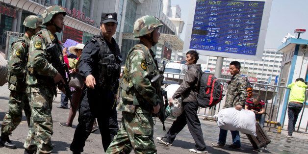 In this Thursday, May 1, 2014 file photo, armed Chinese paramilitary policemen march past the site of the explosion outside the Urumqi South Railway Station in Urumqi in northwest China's Xinjiang Uygur Autonomous Region. Beijingâs tight controls and monopoly on the narrative make it difficult to independently assess if the lethal action has been justified. And Chinese authorities prevent most reporting by foreign journalists inside Xinjiang, making it nearly impossible to confirm the state