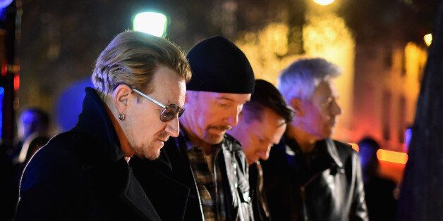 PARIS, FRANCE - NOVEMBER 14: Bono and band members of U2 pay their respects and place flowers on the pavement near the scene of yesterday's Bataclan Theatre terrorist attack on November 14, 2015 in Paris, France. At least 120 people have been killed and over 200 injured, 80 of which seriously, following a series of terrorist attacks in the French capital. (Photo by Jeff J Mitchell/Getty Images)