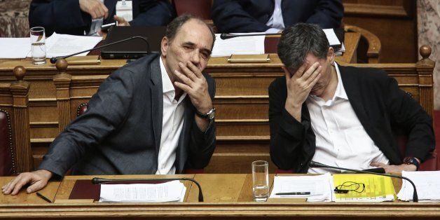 Greece's Finance Minister Euclid Tsakalotos, right, and Greek Economy Minister Giorgos Stathakis attend a committee meeting in the Parliament ahead of a full assembly debate and vote, expected around midnight , in Athens, Thursday, Aug. 13, 2015. The Greek government defended its new bailout program as tough but essential to avoid the nation's financial collapse, as it faced a rebellion in parliament ahead of a vote on the deal later in the day.(AP Photo/Yannis Liakos)