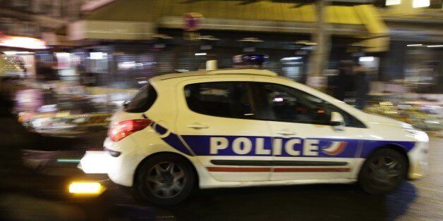 A police vehicle passes by a memorial set-up outside a pizza restaurant, La Casa Nostra, where five people were shot dead on November 13, on November 20, 2015 after a series of deadly attacks in Paris. Gunmen and suicide bombers went on a killing spree in Paris on November 13, attacking the concert hall Bataclan as well as bars, restaurants and the Stade de France. Islamic State jihadists operating out of Iraq and Syria released a statement claiming responsibility for the coordinated attacks that killed 130 and injured over 350. AFP PHOTO / KENZO TRIBOUILLARD (Photo credit should read KENZO TRIBOUILLARD/AFP/Getty Images)