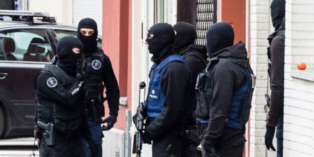 Armed police guard a street in Brussels on Monday, Nov. 16, 2015. A major action with heavily armed police is underway in the Brussels neighborhood of Molenbeek amid a manhunt for a suspect of the Paris attacks. (AP Photo/Geert Vanden Wijngaert)