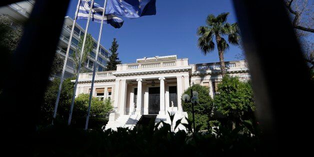 The Greek and the European Union flags are wave outside Maximos Mansion, office of the Prime Minister during a ministerial meeting in Athens, Wednesday, May 13, 2015. Greece's prime minister Alexis Tsipras was holding his second ministerial meeting in as many days Wednesday, when official data confirmed the cash-strapped country is back in recession amid concern over much-delayed bailout talks with creditors. (AP Photo/Thanassis Stavrakis)