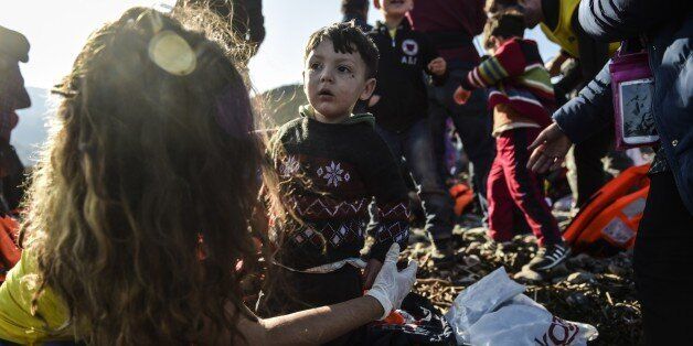 Migrants and refugees receive assistance after arriving on the Greek island of Lesbos after crossing the Aegean Sea from Turkey on November 19, 2015. European leaders tried to focus on joint action with Africa to tackle the migration crisis, as Slovenia became the latest EU member to act on its own by barricading its border. AFP PHOTO/BULENT KILIC (Photo credit should read BULENT KILIC/AFP/Getty Images)