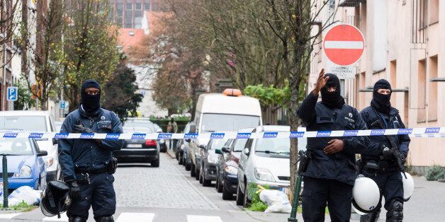 Armed police guard a street in Brussels on Monday, Nov. 16, 2015. A major action with heavily armed police is underway in the Brussels neighborhood of Molenbeek amid a manhunt for a suspect of the Paris attacks. (AP Photo/Geert Vanden Wijngaert)