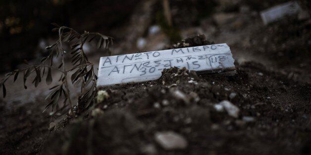 TO GO WITH AFP STORY BY MARINA RAFENBERGA piece of marble reading 'Unidentified child' is placed over the grave of a child who drowned on its way from Turkey to the Greek island of Lesbos, at a makeshift cemetery in Mytilene, on the island of Lesbos, on November 4, 2015. AFP PHOTO / ARIS MESSINIS (Photo credit should read ARIS MESSINIS/AFP/Getty Images)