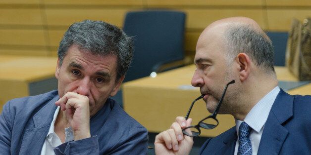 BRUSSELS, BELGIUM - 2015/07/12: Greek Finance Minister Euclid Tsakalotos (L) speaks with Pierre Moscovici (R) is European Commissioner for Economic and Financial Affairs, during the meeting of Eurogroup Finance Ministers. (Photo by Jonathan Raa/Pacific Press/LightRocket via Getty Images)