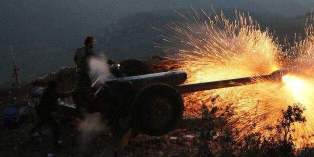 In this photo taken on Saturday, Oct. 10, 2015, Syrian army personnel fire a cannon in Latakia province, about 12 from the border with Turkey in Syria. Backed by Russian airstrikes, the Syrian army has launched an offensive in central and northwestern regions. (Alexander Kots/Komsomolskaya Pravda via AP)