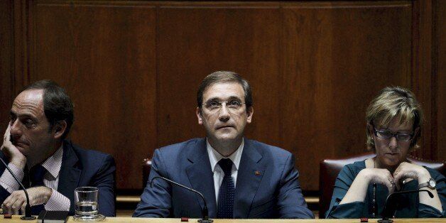 Portuguese Prime Minister Pedro Passos Coelho (C) sits flanked by Portuguese vice prime minister Paulo Portas (L) and Portuguese finance minister Maria Luis Albuquerque (R) during a debate at the Portuguese Parliament in Lisbon on November 9, 2015 where the Portuguese center-right government presents its program before a Parliament dominated by the left. Portuguese Socialist Party's internal political committee said late yesterday it had recommended its MPs support a motion to take down the country's minority centre-right government. AFP PHOTO / PATRICIA DE MELO MOREIRA (Photo credit should read PATRICIA DE MELO MOREIRA/AFP/Getty Images)