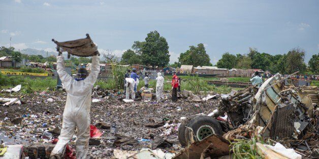 People gather at the site of a cargo plane crash, on a small island in the White Nile river, close to Juba airport, in the Hai Gabat residential area, on November 4, 2015. At least 27 people were killed today when a plane crashed shortly after taking off from South Sudan's capital Juba, an AFP reporter said. Police were pulling the bodies of men, women and children out of the wreckage of the Russian-built Antonov An-12 cargo plane, which smashed into a farming community on an island on the White Nile river, according to the reporter, who counted at least 27 dead. AFP PHOTO / CHARLES LOMODONG (Photo credit should read CHARLES LOMODONG/AFP/Getty Images)