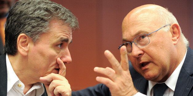 French Finance Minister Michel Sapin talk to Greek Finance Minister Euclid Tsakalotos, left, during a meeting of eurozone finance ministers at the EU Council building in Brussels on Friday, Aug. 14, 2015. (AP Photo/Laurent Dubrule)