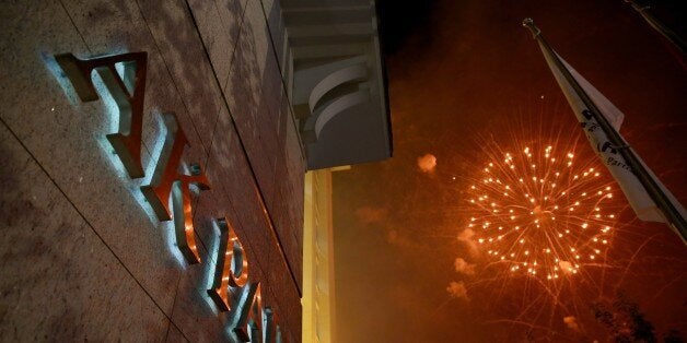 ANKARA, TURKEY - NOVEMBER 2 : Suporters of Justice and Development Party fire fireworks as they celebrate outside the Justice and Development Party headquarters as Turkish Prime Minister Ahmet Davutoglu greets supporters from the balcony after Turkish general election in Ankara, Turkey on November 2, 2015. According to preliminary results, Justice and Development (AK) Party wins over 49 percent of votes in general election. (Photo by Volkan Furuncu/Anadolu Agency/Getty Images)