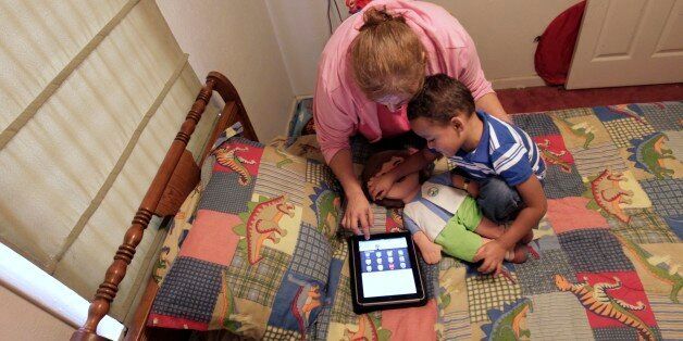 In this Friday, Oct. 21, 2011 photo, Denise Thevenot and her son Frankie Thevenot, 3, play with an iPad in his bedroom at their home in Metairie, La. About 40 percent of 2- to 4-year-olds (and 10 percent of kids younger than that) have used a smartphone, tablet or video iPod, according to a new study by the nonprofit group Common Sense Media. (AP Photo/Gerald Herbert)