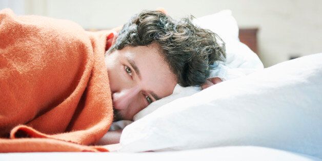 Man with blanket in bed