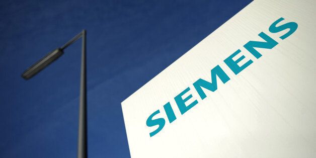FILE - In this Jan. 11, 2012 file picture the Siemens logo is photographed at a building of the company in Munich, Germany. German-based industrial conglomerate Siemens AG is warning on its future profitability, saying that doesn't expect to achieve its targeted profit margin for next year because of economic weakness. Siemens said Thursday July 25, 2013 that it no longer expects to hit a profit margin of at least 12 percent by the 2014 fiscal year, which starts in October. It said the change is