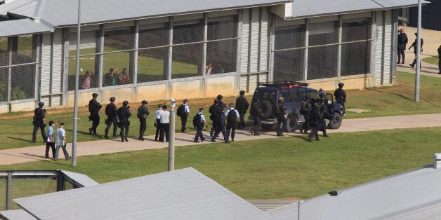 CHRISTMAS ISLAND, AUSTRALIA - MARCH 21: (EUROPE AND AUSTRALASIA OUT) Australian Federal Police officers search the detention centre on Christmas Island after restoring order following rioting amongst asylum seeker detainees. (Photo by Colin Murty/Newspix/Getty Images)