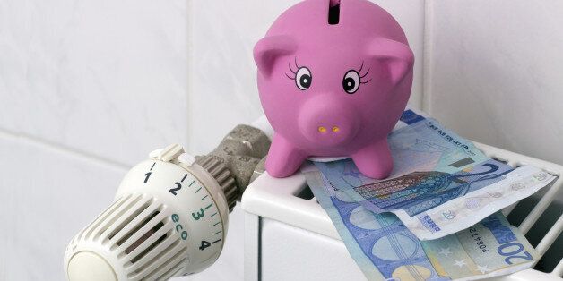Save energy / Piggy bank with euro banknotes next to a thermostat on the heating