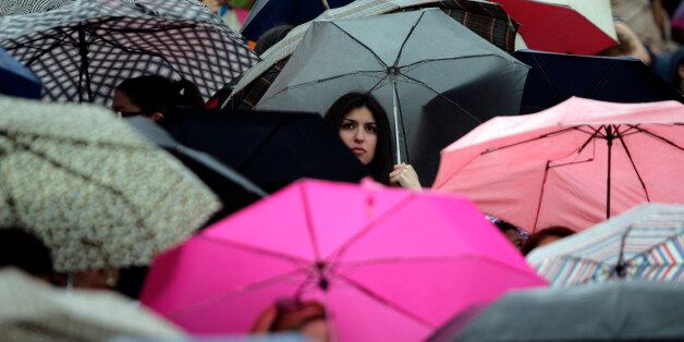 ATHENS, GREECE - MAY 17: Spectators shield from the rain under their umbrellas at the Panathinaiko stadium during the Olympic Torch Handover Ceremony, on May 17, 2012 in Athens, Greece. (Photo by Milos Bicanski/Getty Images)