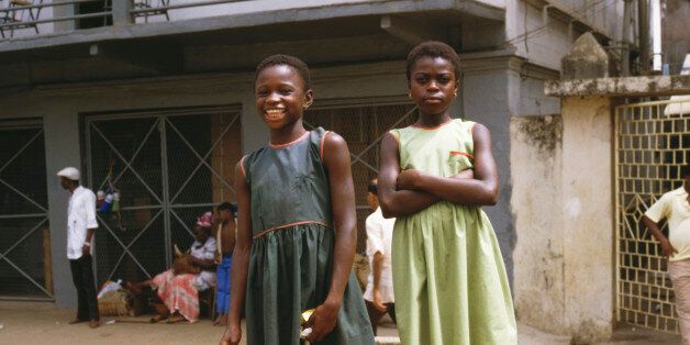 Two young girls pose for the camera along Fourah Bay Road in Freetown, Sierra Leone, March 1985 (Photo by Frances M. Ginter/Getty Images)