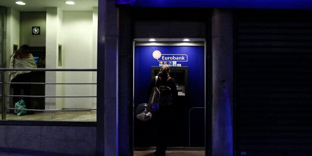 Customers use automated teller machines (ATM) operated by Alpha Bank AE, left, and Eurobank Ergasias SA in Athens, Greece, on Tuesday, Nov. 3, 2015. Greece's four biggest banks may need as little as 1.2 billion euros ($1.3 billion) of new private funds to meet their expected contributions toward filling a capital shortfall, if they succeed in raising 3.2 billion euros through debt swaps. Photographer: Kostas Tsironis/Bloomberg via Getty Images