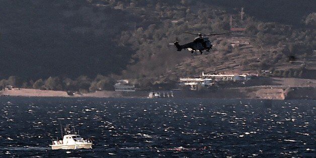 Greek coast guard try to save refugees and migrants during a rescue operation, after boat sunk while attempting to reach the Greek island of Lesbos from Turkey, on October 28, 2015. At least five migrants including three children, died on October 28, 2015 after four boats sank between Turkey and Greece, as rescue workers searched the sea for dozens more, the Greek coastguard said. The new accidents brought to 34 the number of migrants found dead in Greek waters this month, according to an AFP ta
