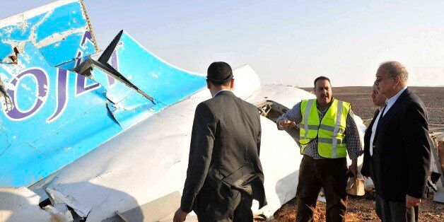 In this image released by the Prime Minister's office, Sherif Ismail, right, looks at the remains of a crashed passenger jet in Hassana Egypt, Friday, Oct. 31, 2015. A Russian aircraft carrying 224 people, including 17 children, crashed Saturday in a remote mountainous region in the Sinai Peninsula about 20 minutes after taking off from a Red Sea resort popular with Russian tourists, the Egyptian government said. There were no survivors.(Suliman el-Oteify, Egypt Prime Minister's Office via AP)