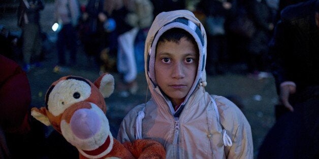 A young boy poses with a soft toy as migrants and asylum seekers wait to enter a registration camp near Gevgelija on October 26, 2015. The EU pledged to help set up 100,000 places in reception centres along the migrant route through the Balkans, in a bid to defuse rising tensions on its eastern frontier over how to deal with the crisis. AFP PHOTO / NIKOLAY DOYCHINOV (Photo credit should read NIKOLAY DOYCHINOV/AFP/Getty Images)