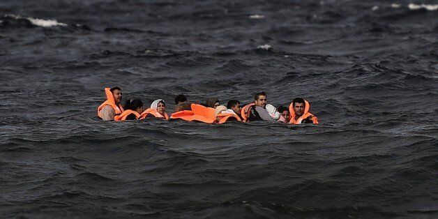 Refugees and migrants cross by boat the Aegean sea from Turkey, to reach the Greek island of Lesbos, on October 31, 2015. AFP PHOTO / ARIS MESSINIS (Photo credit should read ARIS MESSINIS/AFP/Getty Images)