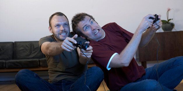 Two mid adult men playing video games