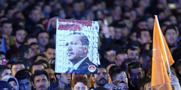 Supporters of the Justice and Development Party (AKP) hold a banner of Turkish President Recep Tayyip Erdogan during a speech by Turkish Prime Minister Ahmet Davutoglu (not pictured) at the AKP headquarters in Ankara on November 2, 2015, following Turkish general elections. Turkey's Justice and Development Party was preparing for government November 2 with a decisive mandate after a surprise election turnaround that strengthens the hand of President Recep Tayyip Erdogan. The AKP, founded by the polarising strongman who has dominated Turkish politics for more than a decade, on November 1 reclaimed the parliamentary majority it has lost just five months ago, confounding opinion polls which had predicted another hung parliament. AFP PHOTO / ADEM ALTAN (Photo credit should read ADEM ALTAN/AFP/Getty Images)