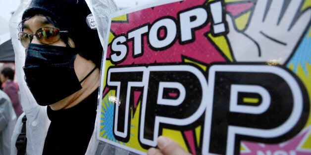 FILE - In this April 22, 2104 file photo, a protester holds a placard during a rally against the Trans-Pacific Partnership (TPP) in Tokyo. Just over two decades after lobbying unsuccessfully against the North American Free Trade Agreement, U.S. labor unions are again voicing strong reservations to a proposed major trade-liberalization deal. (AP Photo/Shizuo Kambayashi, File)