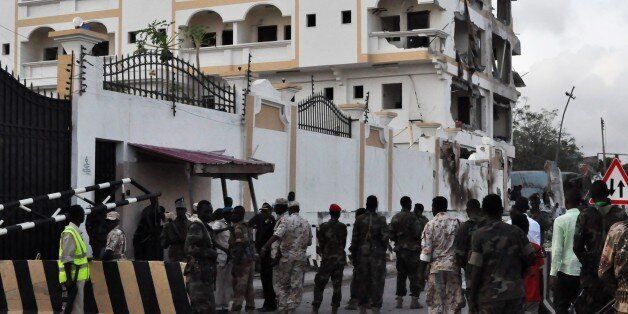 Somali soldiers stand in front of the damaged Jazeera Palace hotel following a suicide attack in Mogadishu on July 26, 2015. Somalia's Shebab insurgents killed at least six people today when they detonated a huge car bomb at a heavily guarded hotel in the capital Mogadishu housing diplomatic missions, officials and witnesses said. AFP PHOTO / STRINGER (Photo credit should read -/AFP/Getty Images)