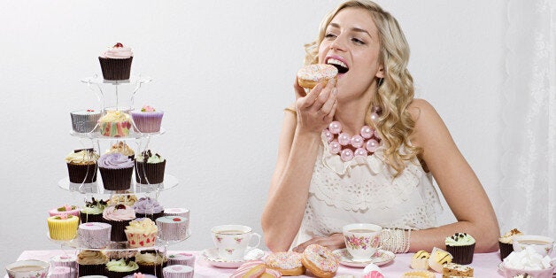 Woman indulging in doughnuts and cakes