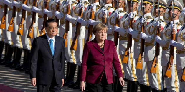 Chinese Premier Li Keqiang, left walks with German Chancellor Angela Merkel during a welcome ceremony held outside the Great Hall of the People in Beijing, China, Thursday, Oct. 29, 2015. (AP Photo/Ng Han Guan)