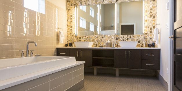 Luxurious modern home bathroom with tiled floor, walls and soaking tub.