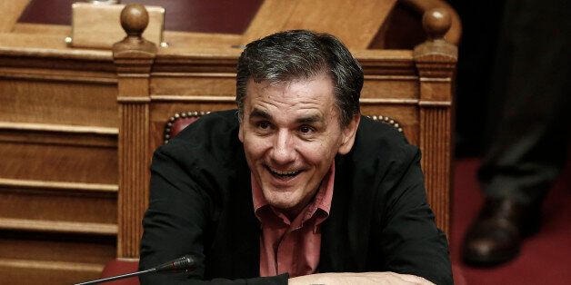 Greece's Finance Minister Euclid Tsakalotos smiles during a parliament vote on a new austerity reform package in Athens, Oct. 17, 2015. Greece's Prime Minister Alexis Tsipras faces his first test in the country's newly elected parliament Friday since a bailout rebellion split his party and triggered a snap general election last month. (AP Photo/Yorgos Karahalis)