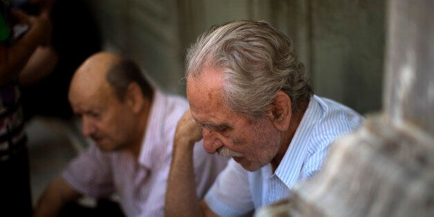 Pensioners wait outside the main gate of the national bank of Greece to withdraw a maximum of 120 euros ($134) in central Athens, Friday, July 10, 2015. Greece's Prime Minister Alexis Tsipras will seek backing for a harsh new austerity package from his party Friday to keep his country in the euro. (AP Photo/Emilio Morenatti)