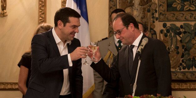 French President Francois Hollande, right and Greek Prime Minister Alexis Tsipras raise their glasses during a dinner at the Presidential Palace in Athens, Thursday, Oct. 22, 2015. Hollande is in Greece for a two-day visit, as Greece seeks help from European rescue lenders for relief on its massive bailout debts. (AP Photo/Petros Giannakouris)