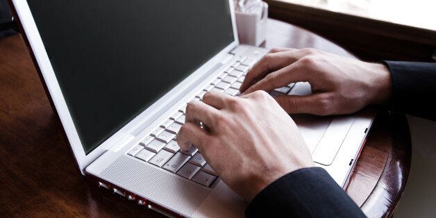Hands of man typing on laptop
