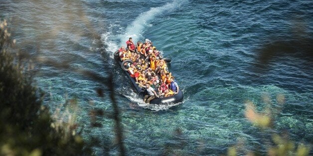 LESBOS ISLAND, GREECE - SEPTEMBER 19: Refugees on a rubber boat reach the shore of Eftalou beach, north of the port city of Mytilini after crossing the Aegean sea from Turkey on September 19, 2015 in Lesbos Island, Greece. (Photo by Ozge Elif Kizil/Anadolu Agency/Getty Images)