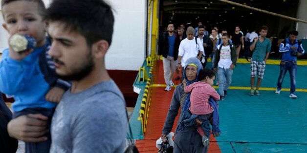 Immigrants and refugees arrive on a ferry from the Greek island of Lesbos at Athens' port of Piraeus, Monday, Sept. 28, 2015. The Greek ferry Elefhterios Venizelos is part of special ferry service for refugees and migrants that carries 2,500 paying passengers. More than 250,000 asylum seekers have passed through Greece so far this year. (AP Photo/Thanassis Stavrakis)