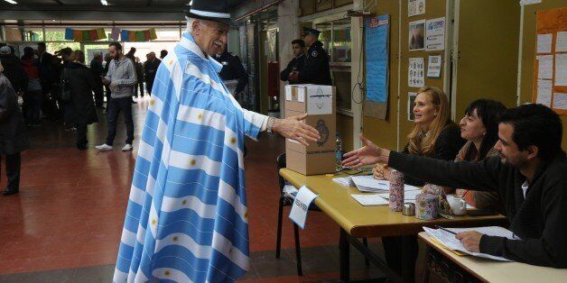 BUENOS AIRES, ARGENTINA - OCTOBER 25: A man wearing Argentina flags greets returning officers before he casts his ballot at a polling station during the presidential elections in Buenos Aires, Argentina on October 25, 2015. (Photo by Omer Musa Targal/Anadolu Agency/Getty Images)