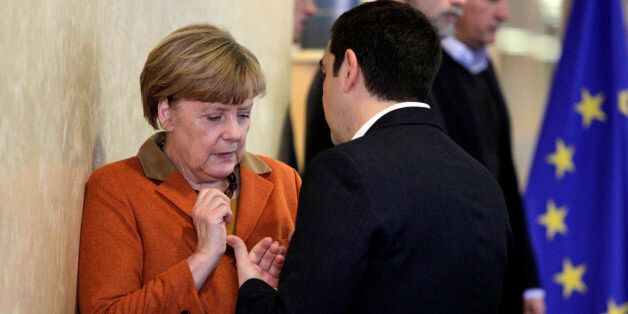 German Chancellor Angela Merkel, left, speaks with Greek Prime Minister Alexis Tsipras prior to a round table meeting during an EU summit at EU headquarters in Brussels on Sunday, Oct. 25, 2015. EU leaders meet on Sunday to discuss refugee flows along the Western Balkans route. (AP Photo/Francois Walschaerts)