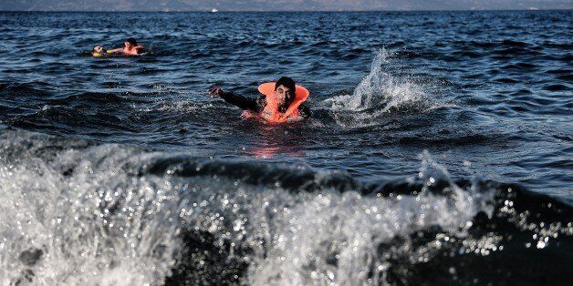 Two men swim towards the Greek island of Lesbos as migrants and asylum seekers cross the Aegean sea from Turkey on October 27, 2015. More than 700,000 refugees and migrants have reached Europe's Mediterranean shores so far this year, amid the continent's worst migration crisis since World War II, the UN refugee agency said. AFP PHOTO / ARIS MESSINIS (Photo credit should read ARIS MESSINIS/AFP/Getty Images)