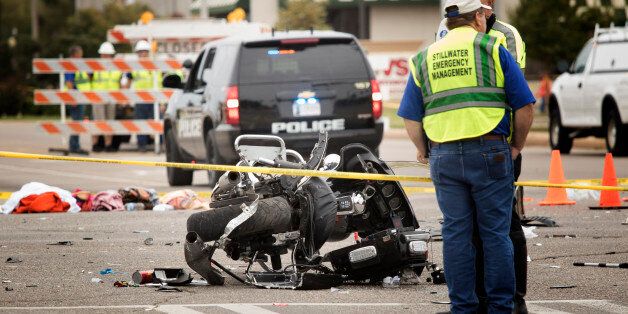 STILLWATER, OK - OCTOBER 24: Emergency officials stand over a crash scene including a wrecked police motorcycle after a suspected drunk driver crashed into a crowd of spectators during the Oklahoma State University homecoming parade near the Boone Pickens Stadium on October 24, 2015 in Stillwater, Oklahoma. The car slammed into a crowd, killing three and injuring at least 22 before the Kansas Oklahoma State football game. (Photo by J Pat Carter/Getty Images)