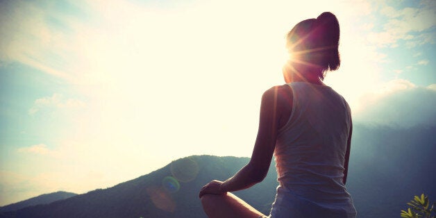 young yoga woman at sunrise mountain peak