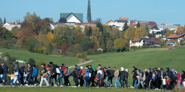 Migrants are led by German Federal Police to an emergency accommodation center in Wegscheid, southern Germany, Tuesday Oct. 27, 2015 after crossing the Austrian-German border. (Armin Weigel/dpa via AP)